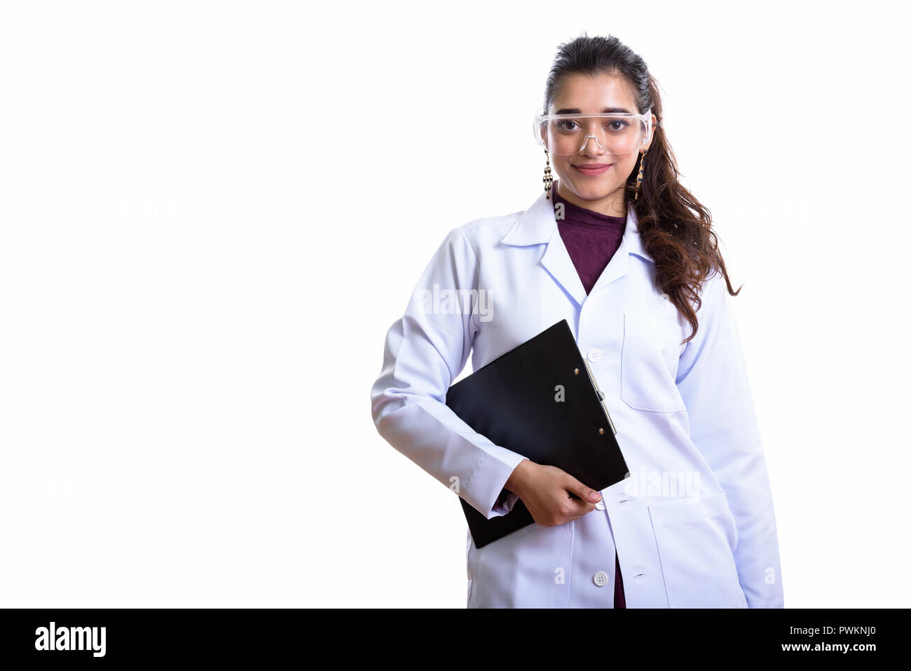 Young beautiful Indian woman doctor holding clipboard between ha Stock Photo