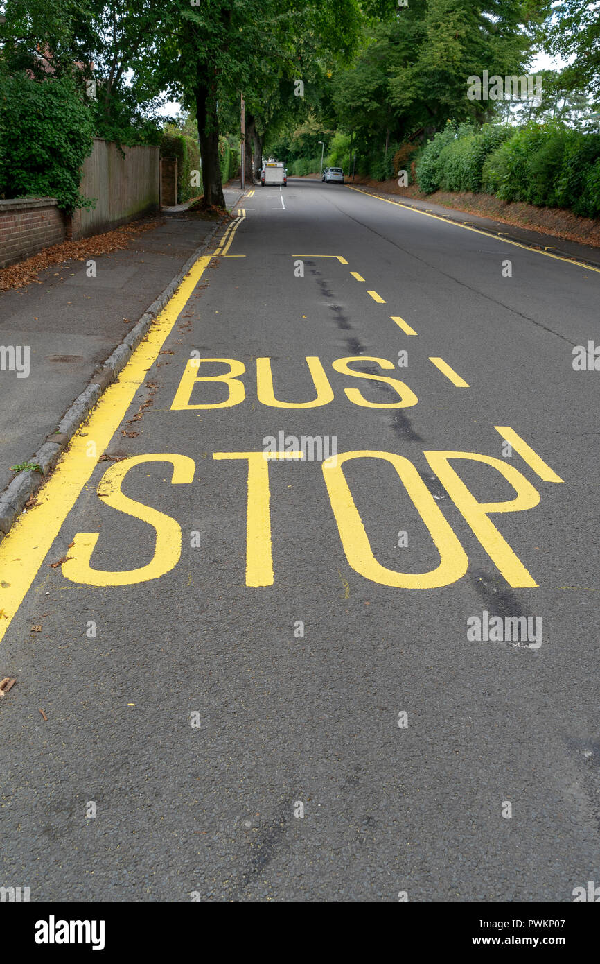 Bus stop sign in yellow paint on road surface Stock Photo
