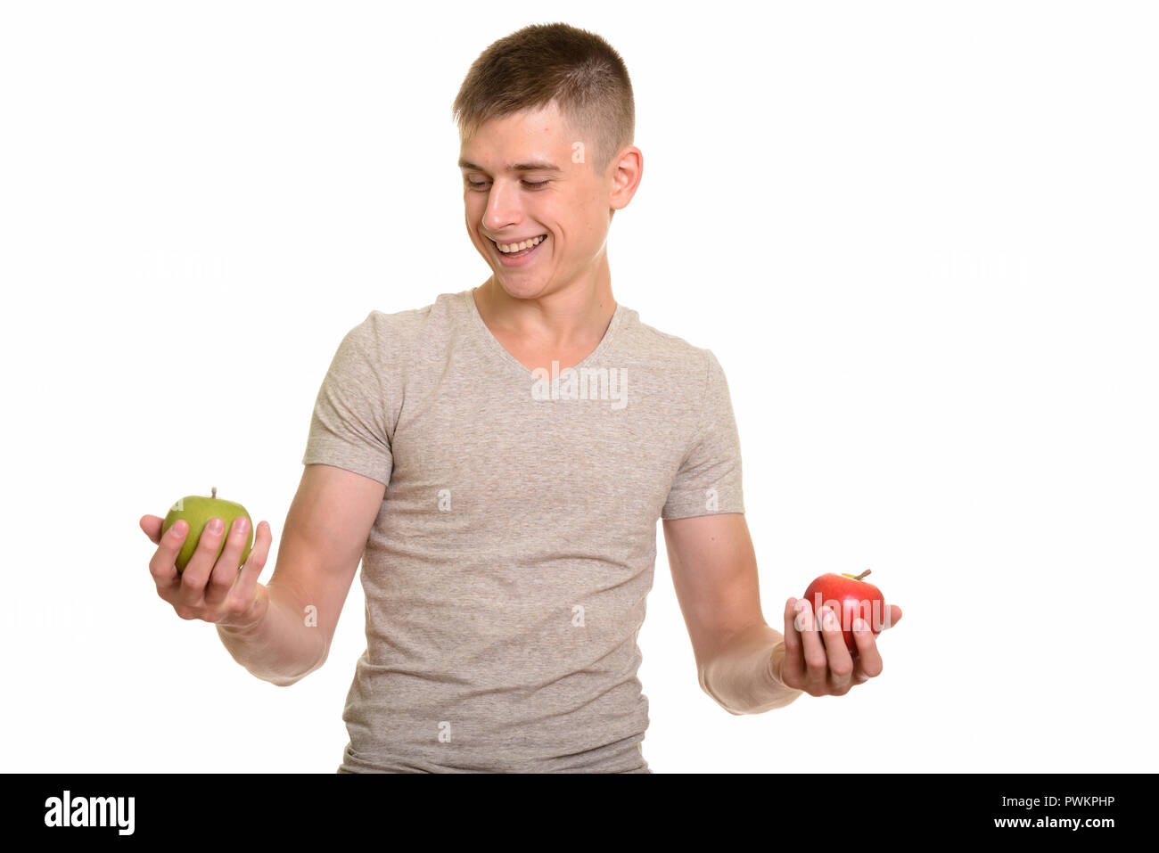 Young happy Caucasian man smiling while choosing between red and Stock Photo