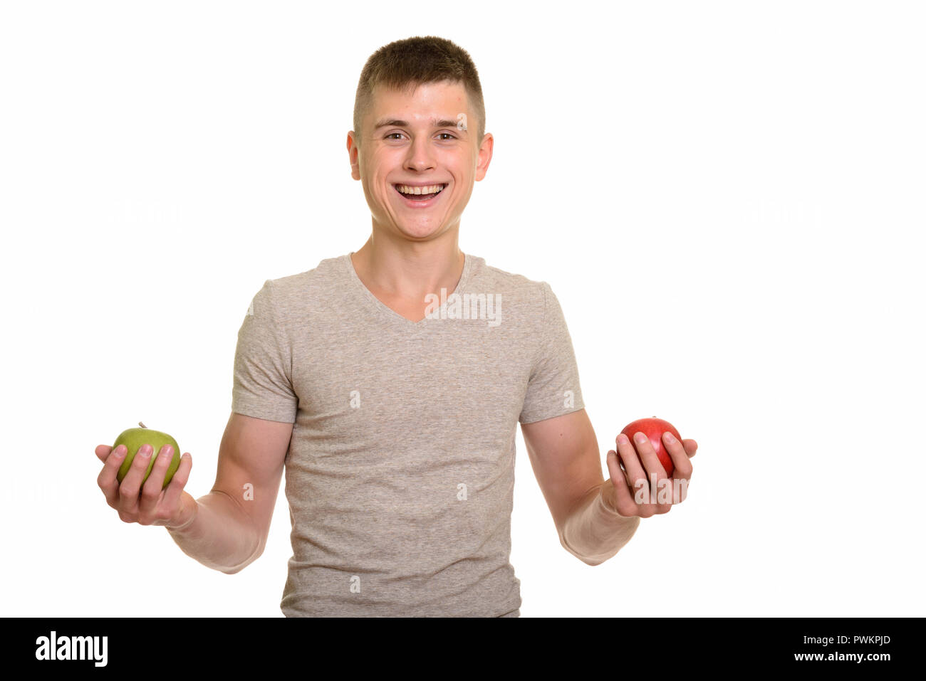 Young happy Caucasian man smiling while holding red and green ap Stock Photo