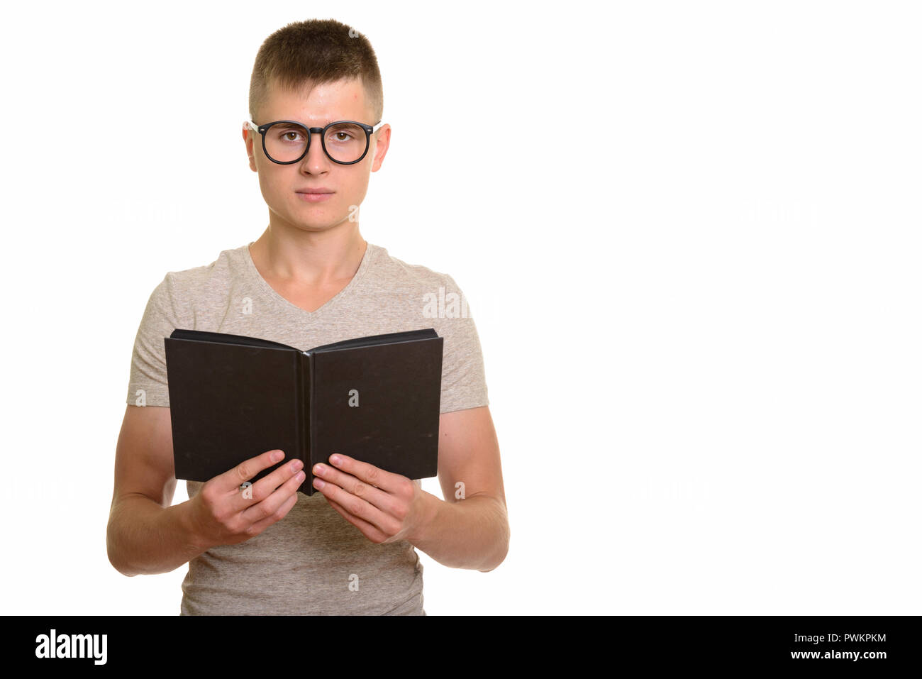 Young Caucasian nerd student man holding book Stock Photo