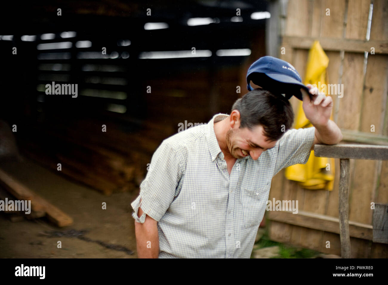 Man outside shed tipping off baseball cap Stock Photo Alamy