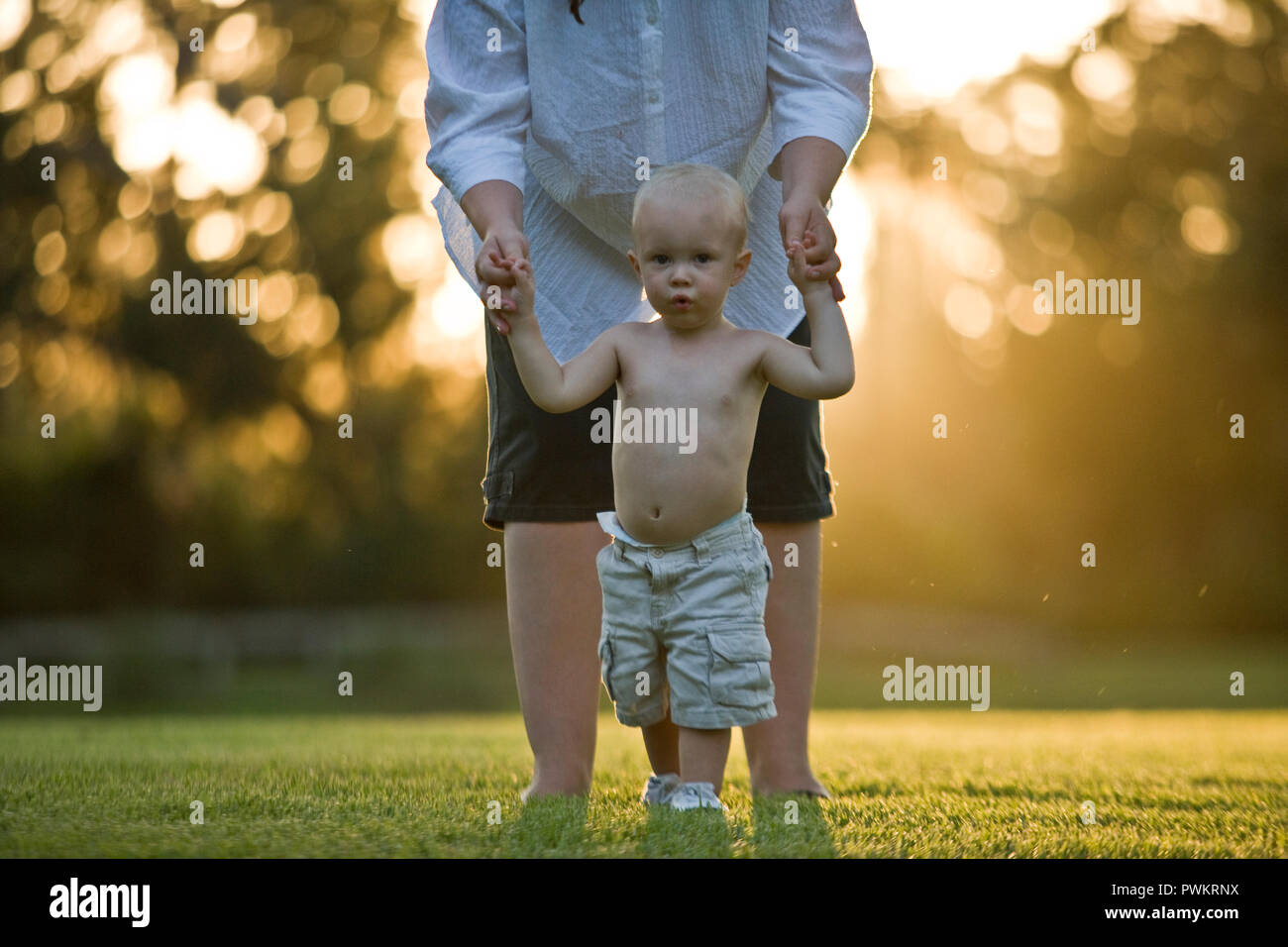 portrait of a young toddler holding hands with his father. Stock Photo