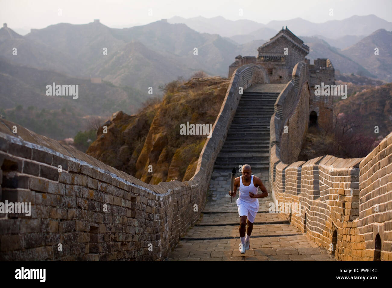 Man carrying the Olympic torch on the Great Wall Of China Stock Photo