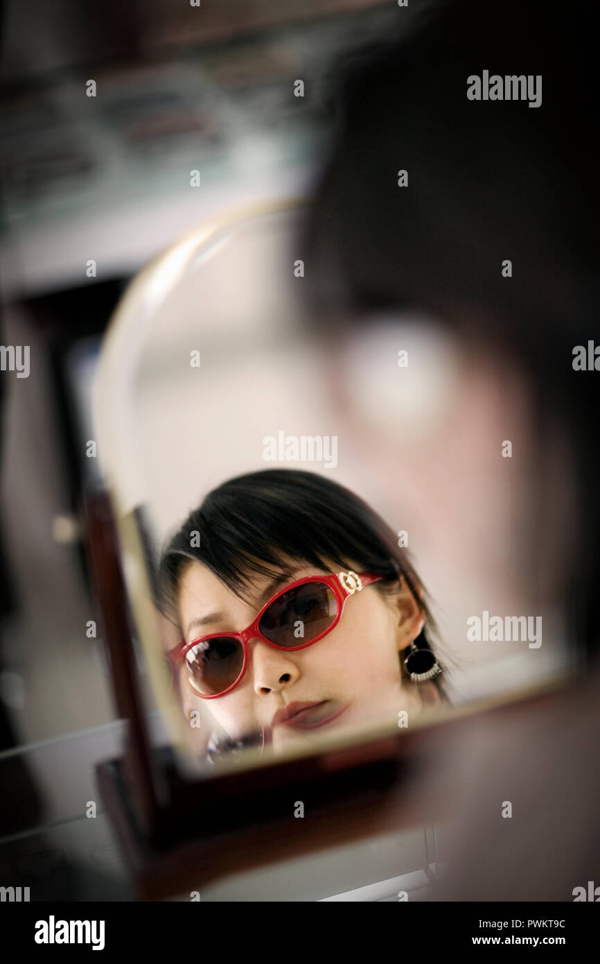 Woman trying on sunglasses in store Stock Photo