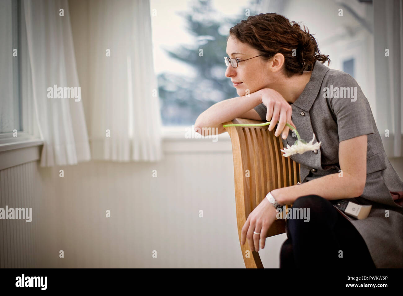 Contemplative young woman resting her chin on her arm while sitting in