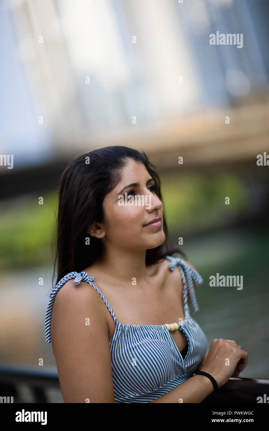 Young woman standing near an inner city river. Stock Photo