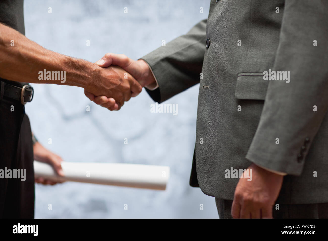 Architect handing blueprints to businessman. Stock Photo