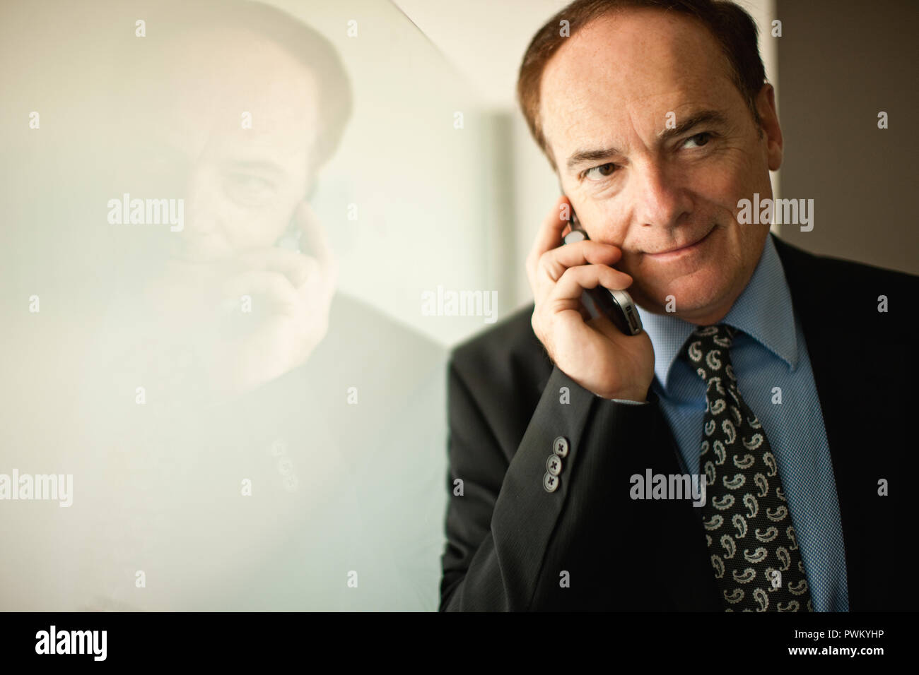 Businessman in suit talks on cellphone. Stock Photo