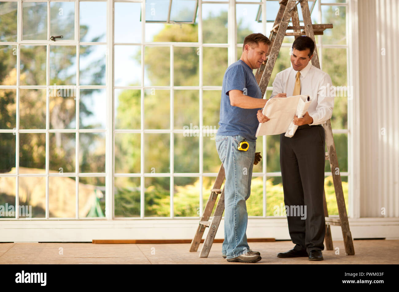 Two businessmen looking at samples on a construction site. Stock Photo