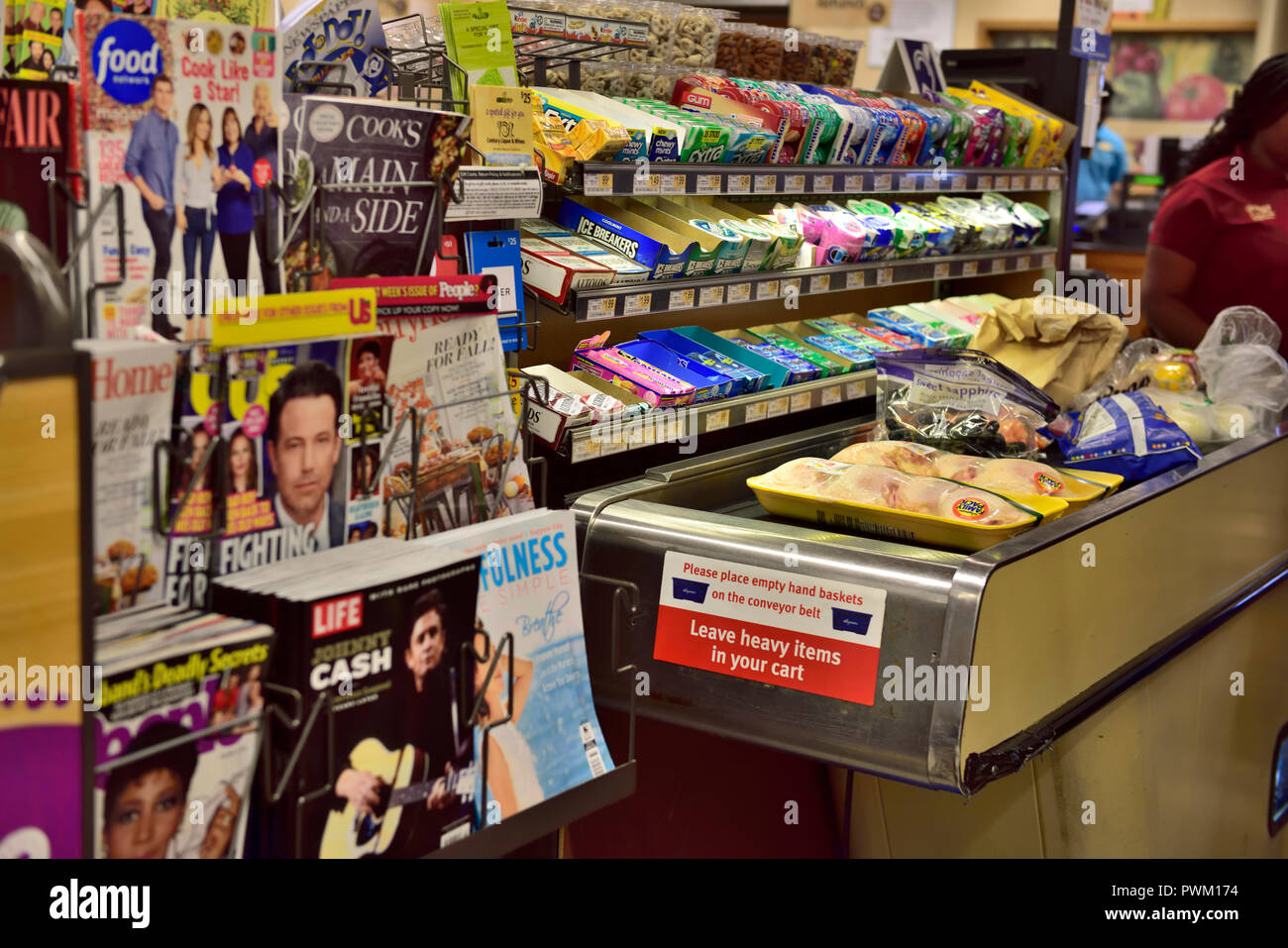 Checkout with conveyor belt past the magazines and sweets display in supermarket for impulse selling, USA Stock Photo