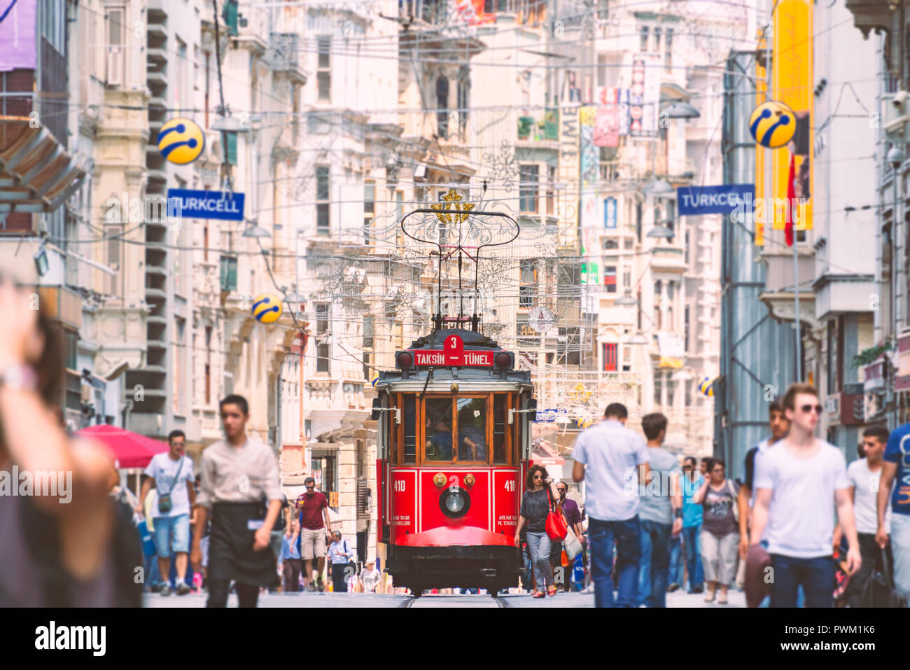 ISTANBUL, TURKEY - JULY 5, 2014: Old red tram in Taksim, Beyoğlu, Istanbul, Turkey. Historical Istiklal street in city centre with people walking arou Stock Photo