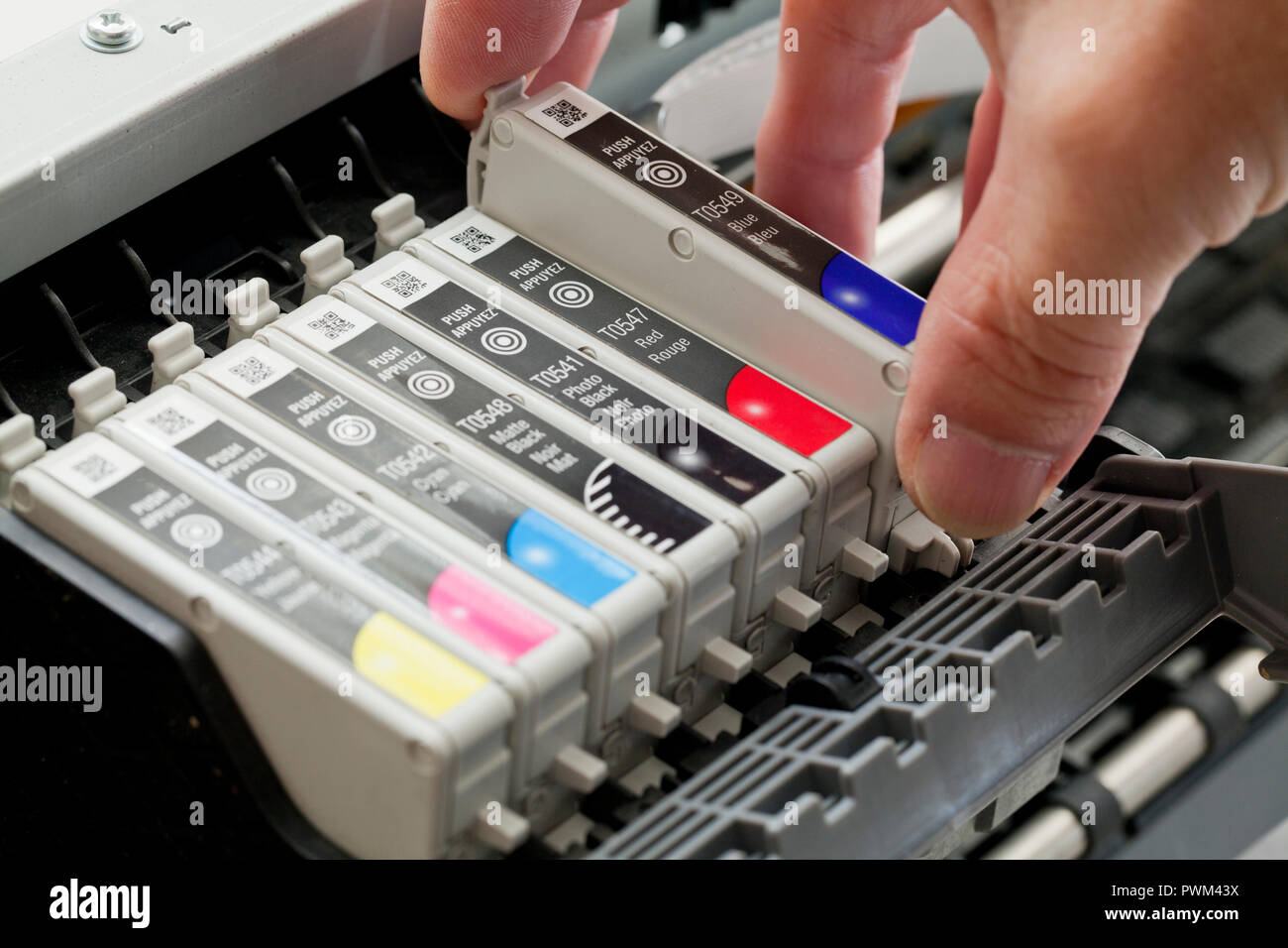 Man replacing an ink cartridge on a color inkjet printer (close up) - USA Stock Photo