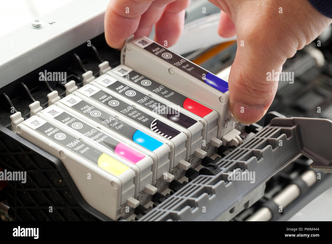 Man replacing an ink cartridge on a color inkjet printer (close up