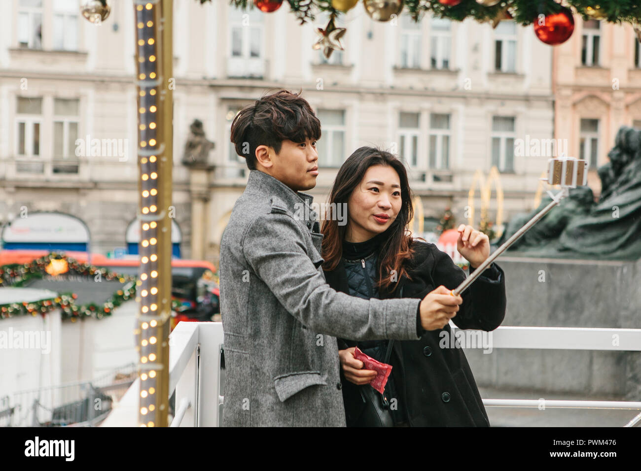 Prague, December 25, 2017: Young Asian couple taking selfie in memory of Prague in the Czech Republic during the Christmas holidays. Stock Photo