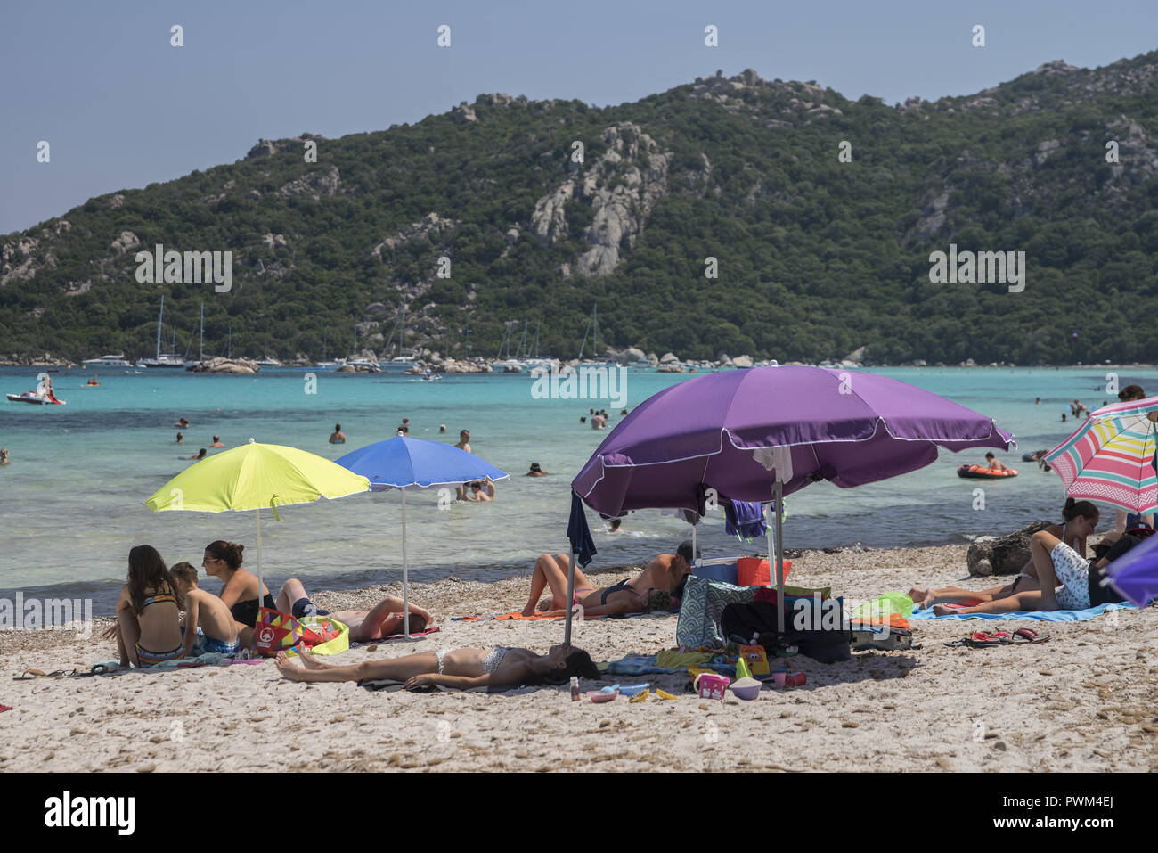 People relaxing on the beach and in the water. Beach of Santa Giulia in Corsica. Plaża Santa Giulia na Korsyce. Ludzie wypoczywający na plaży. Stock Photo