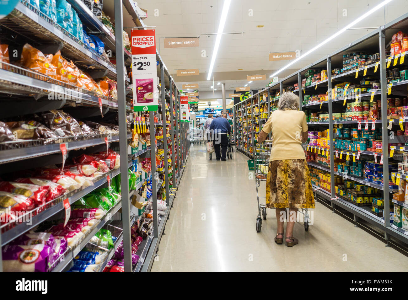 Shoppers pushing trolleys down an aisle at Woolworths supermarket,Tamworth NSW Australia. Stock Photo