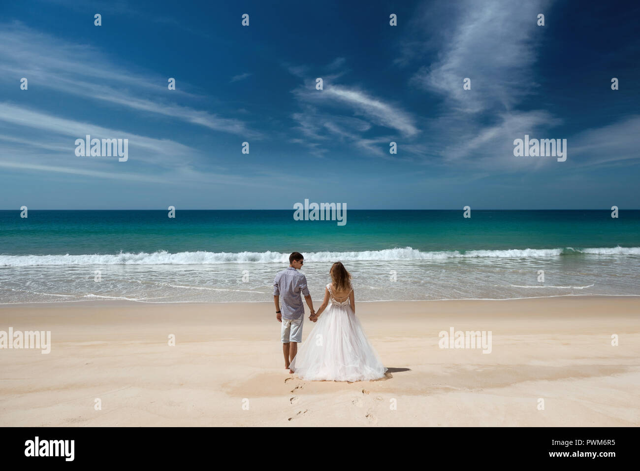 Wedding couple stands at idyllic sea beach. Space for text Stock Photo
