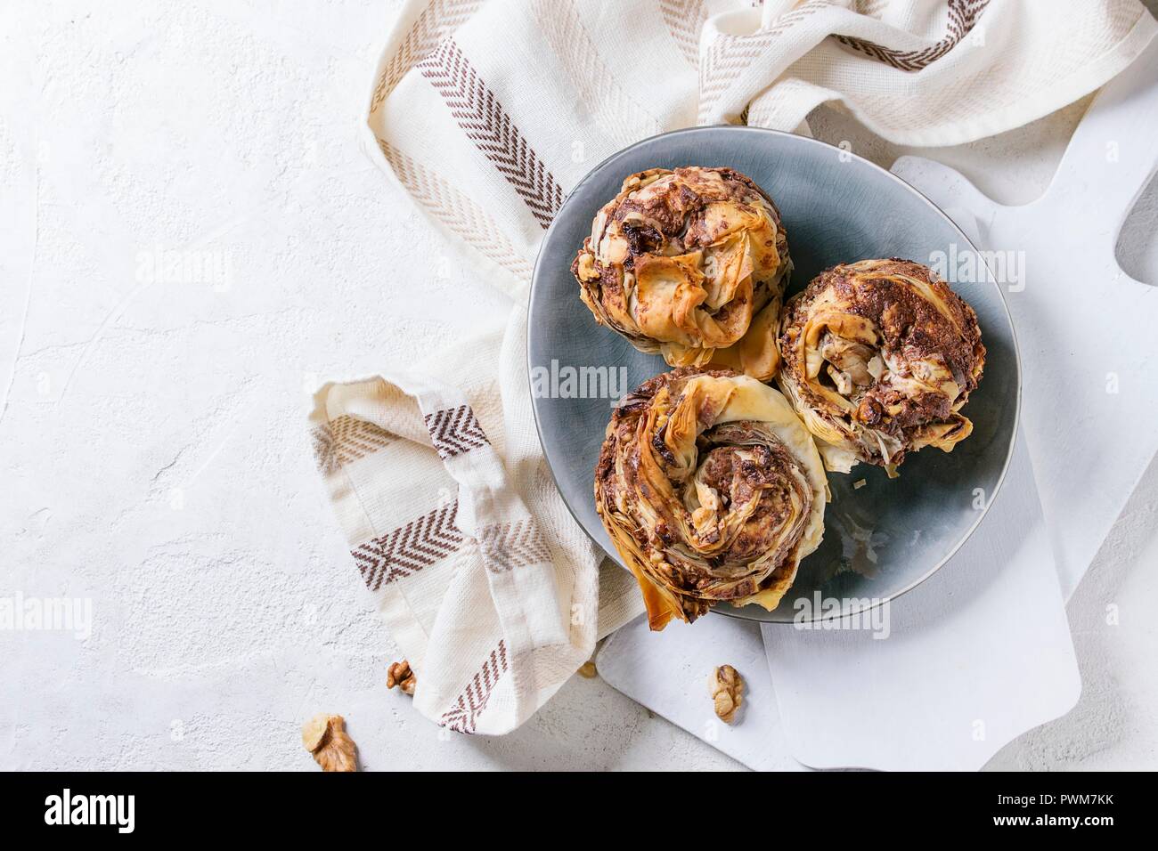 Filo pastry dough with chocolate nutella cream and walnuts on gray plate Stock Photo