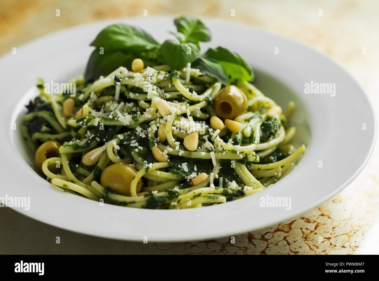 Spaghetti with spinach pesto and green olives Stock Photo