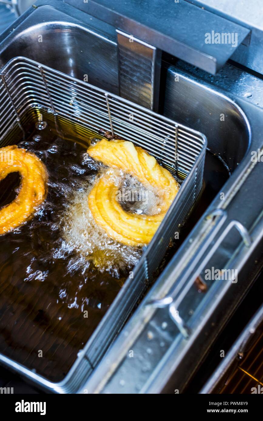 Churros in a deep fat fryer with oil Stock Photo - Alamy