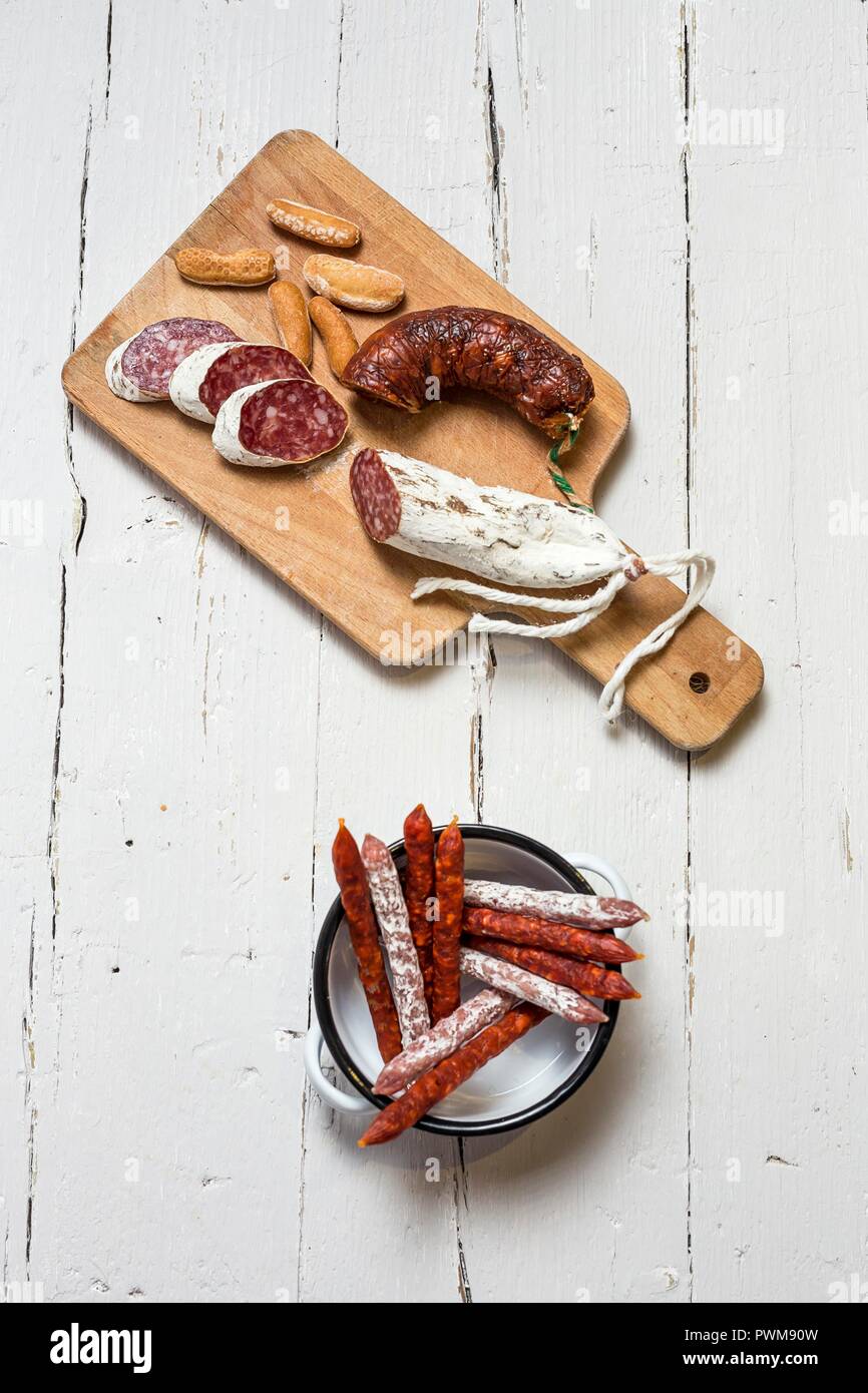 Various Spanish sausages in an enamel dish and on a wooden board (top view) Stock Photo