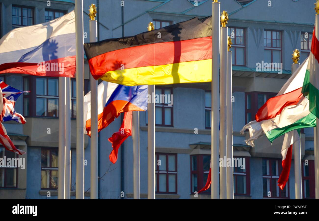 Many flags from around the world blowing in suncshine in front of historic European building in Prague Stock Photo