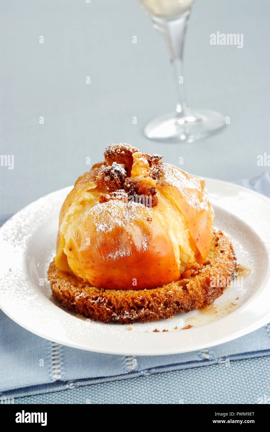 A baked apple served on a slice of panettone Stock Photo