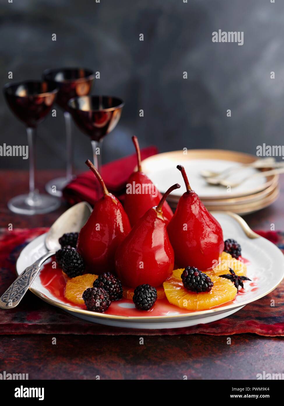 Poached red wine pairs with blackberries and orange slices Stock Photo