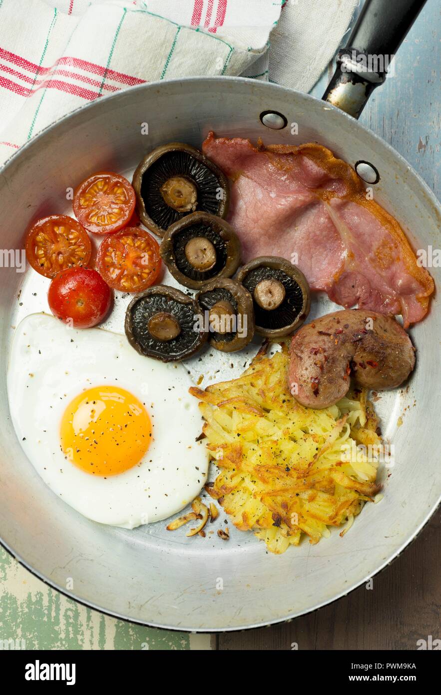 A full English breakfast with a fried egg, bacon, hash browns
