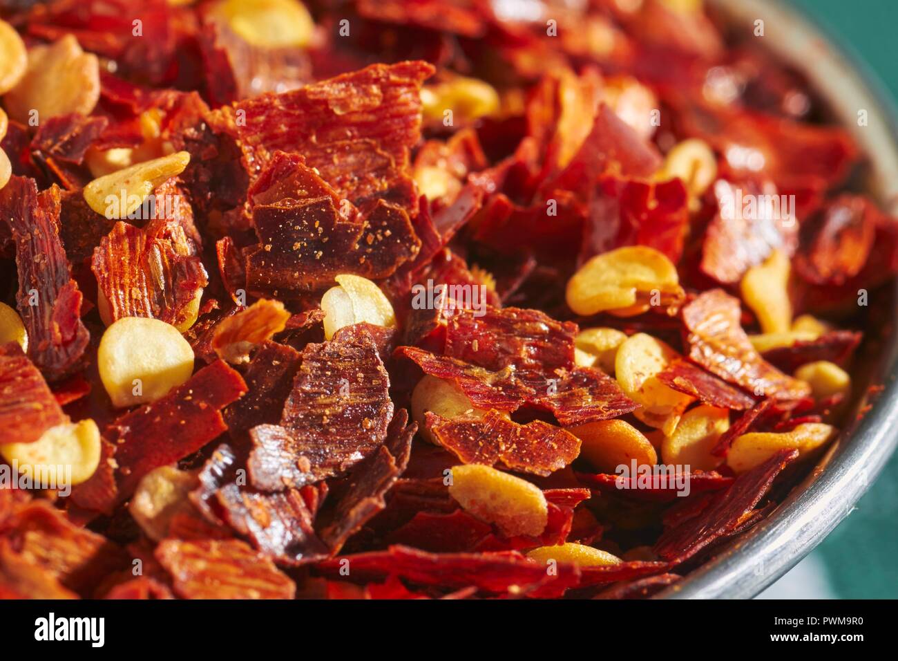 Chilli flakes in a metal bowl Stock Photo