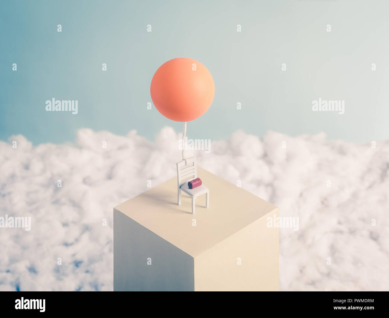 Chair and a Balloon, flying into the sky free from its burden, a brick Stock Photo