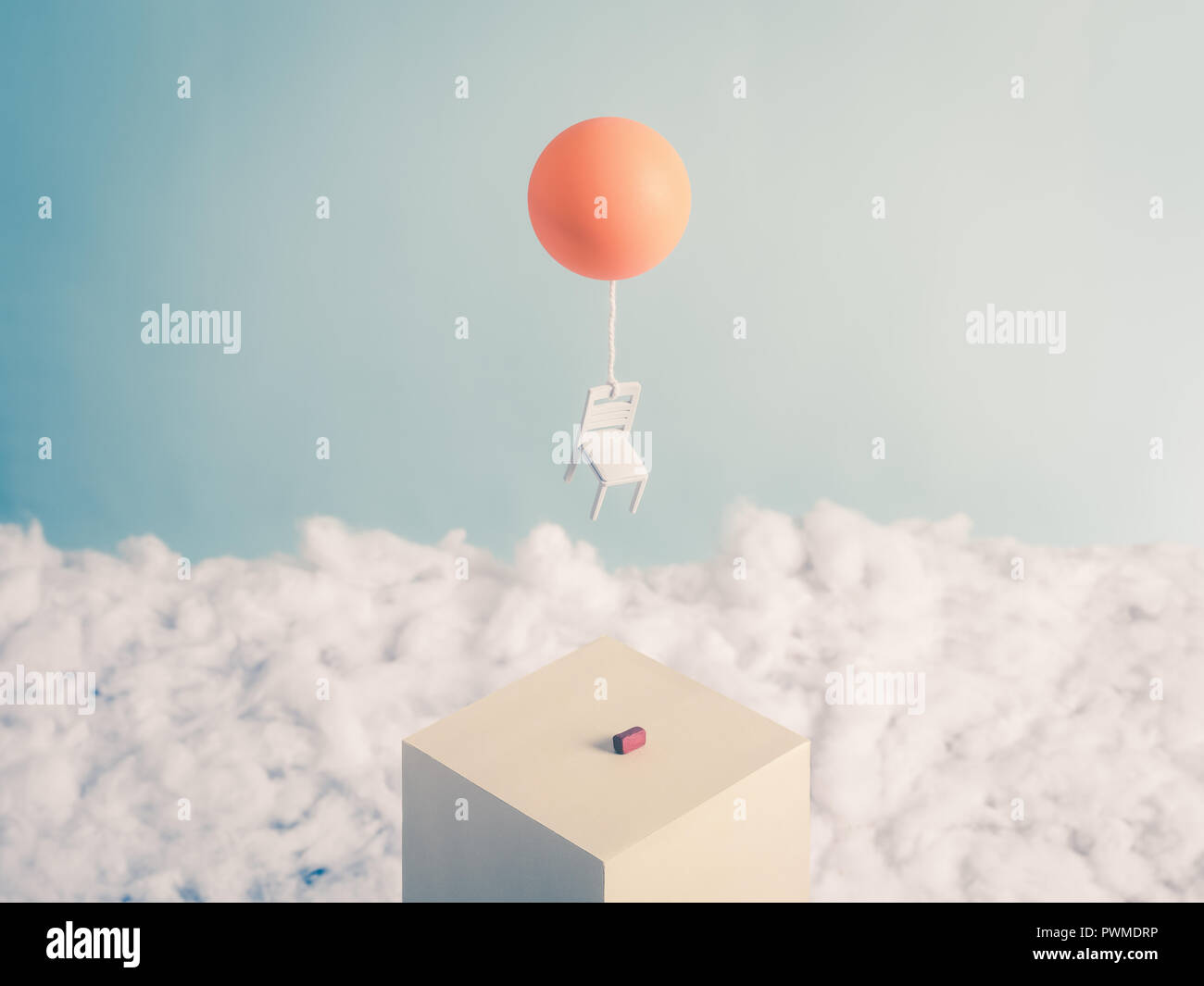 Chair and a Balloon, flying into the sky free from its burden, a brick Stock Photo
