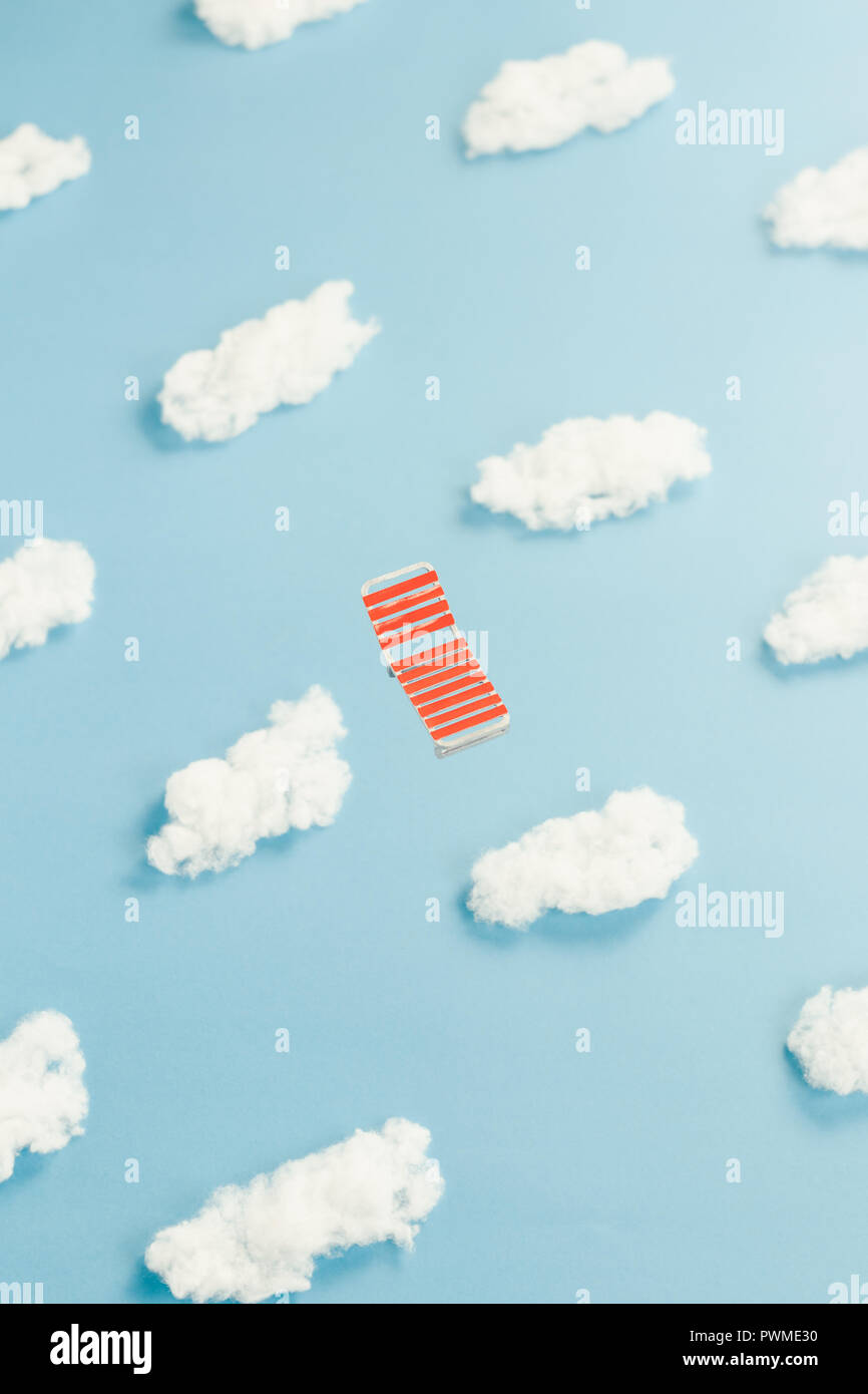 Flying red lawn chair in the sky Stock Photo