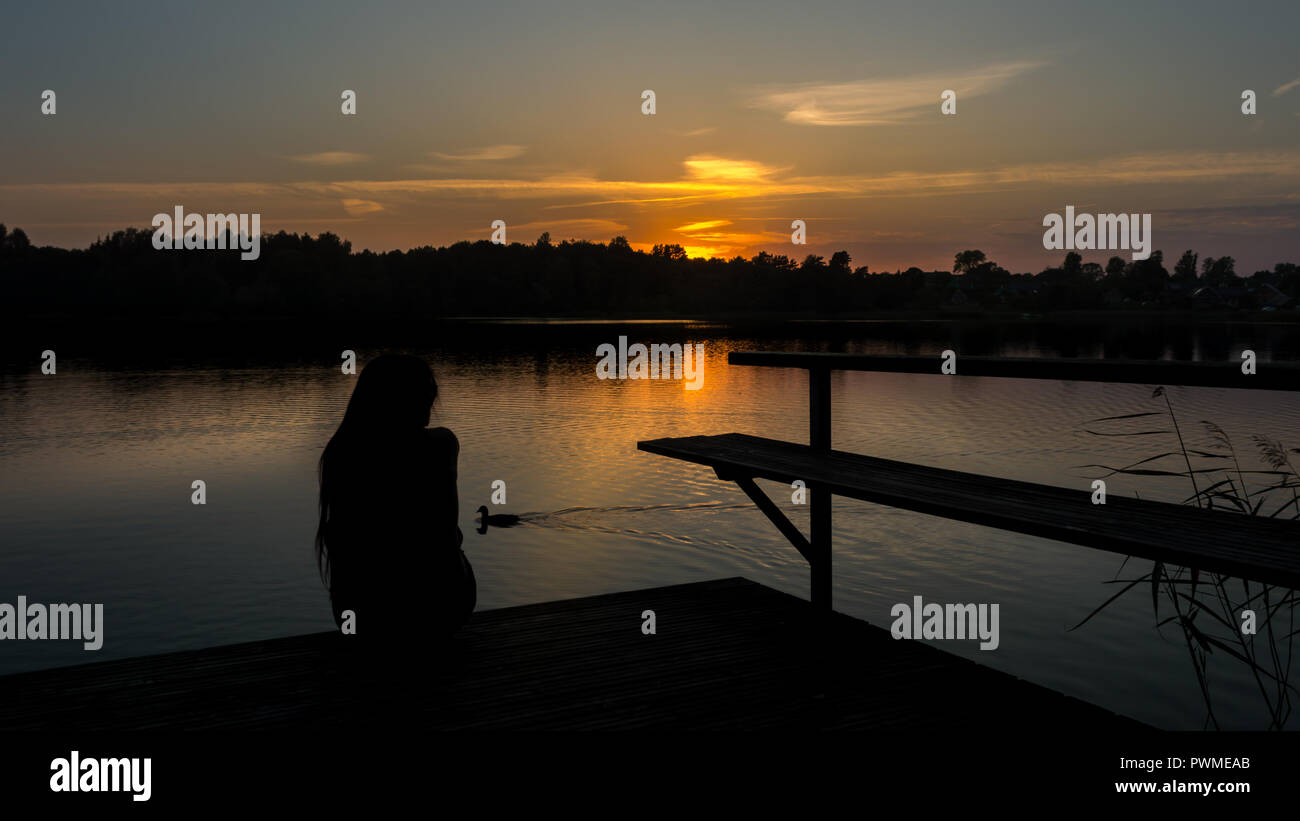 Woman sitting on wood bridge hi-res stock photography and images - Alamy