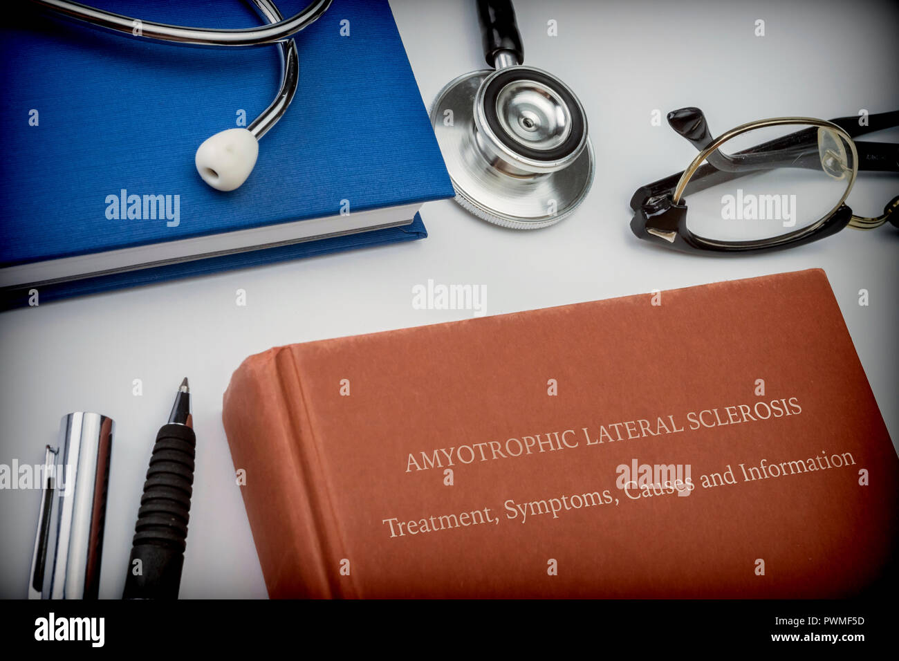 Titled book Amyotrophic Lateral Sclerosis along with medical equipment, conceptual image Stock Photo