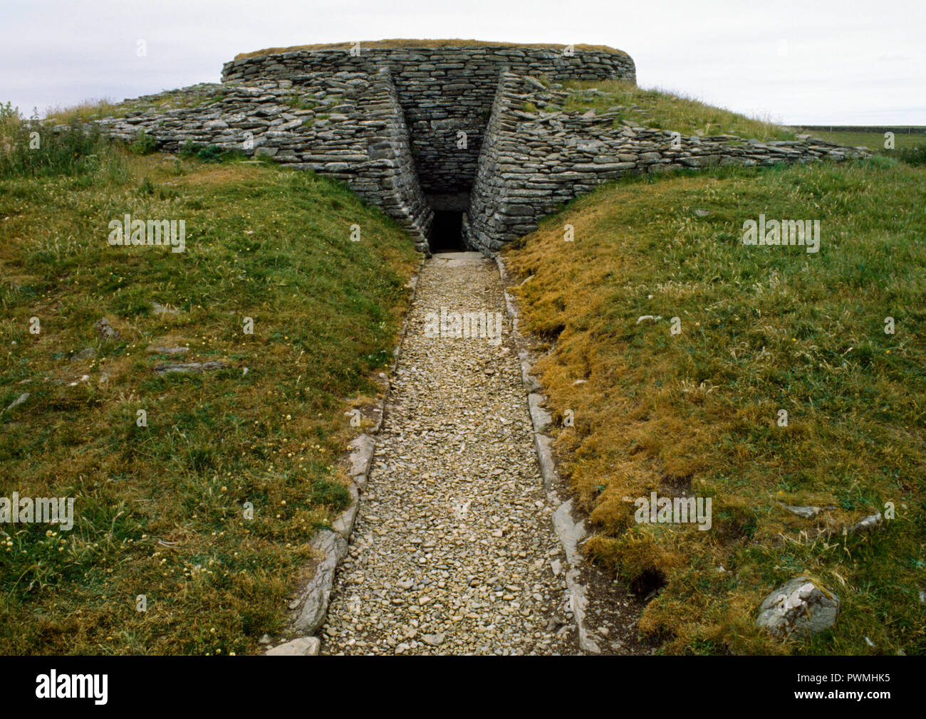 View NW of the consolidated entrance passage & exterior of Quoyness Neolithic chambered cairn, Sanday, Orkney, showing the surrounding rubble platform Stock Photo