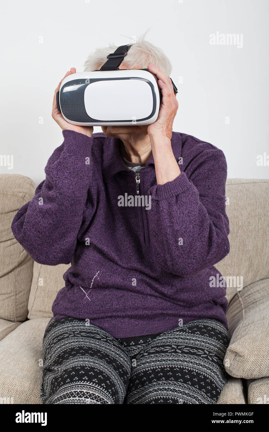 Elderly retired woman experiencing virtual reality video with headset