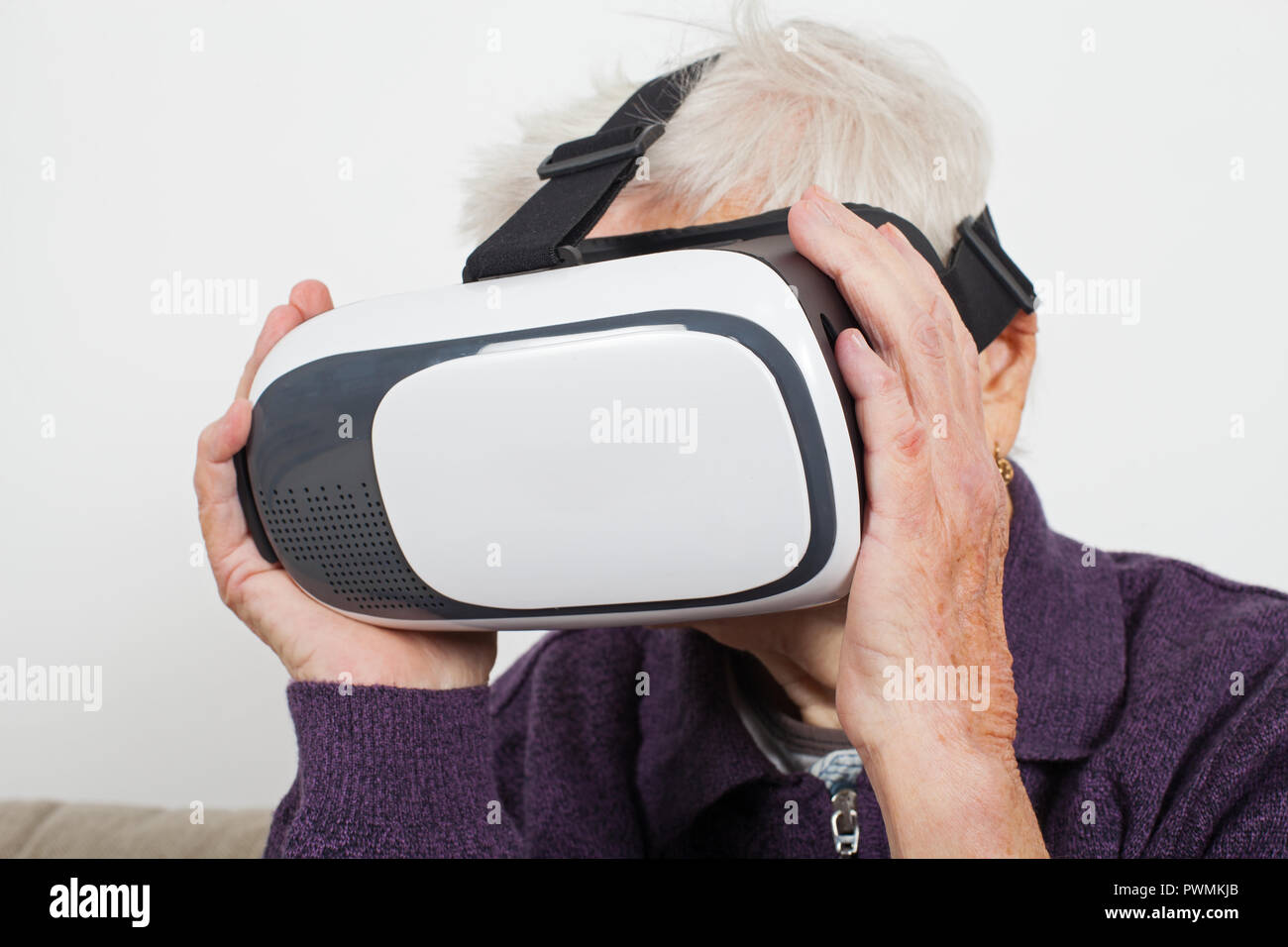 Elderly retired woman experiencing virtual reality video with headset