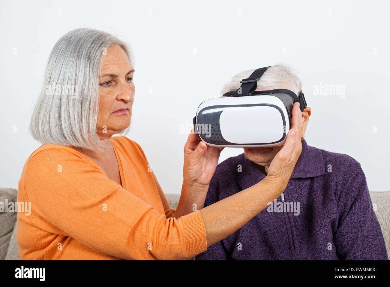 Elderly women experiencing virtual reality video with headset Stock
