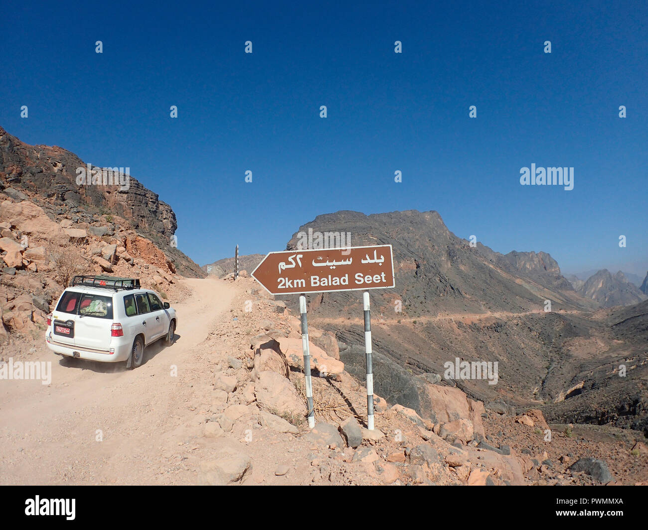 Oman, wadi bani Awf, a four wheel drive white landcruiser is passing on ...