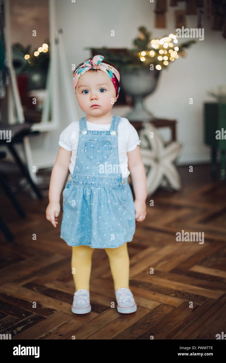 Little cute and pretty girl in jeans dress and bandage on head in retro  style Stock Photo - Alamy