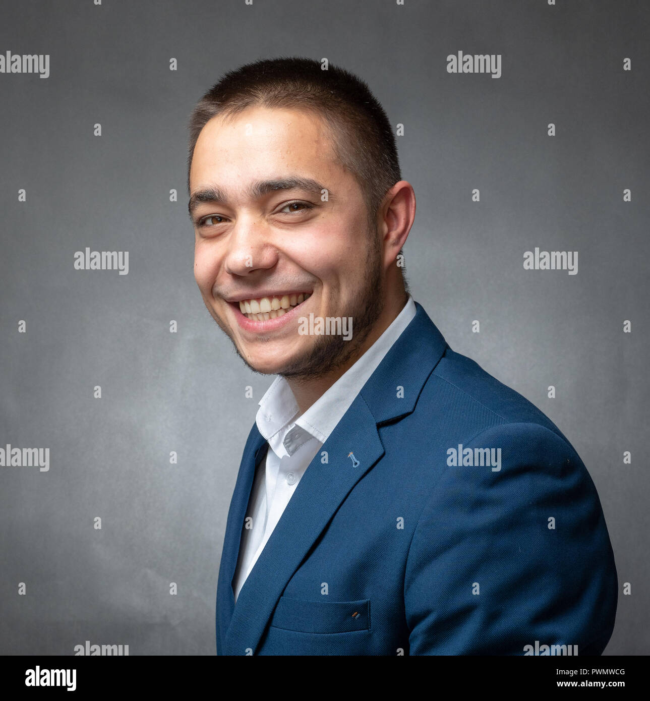 Handsome successfull businessman in blue suit sitting and showing