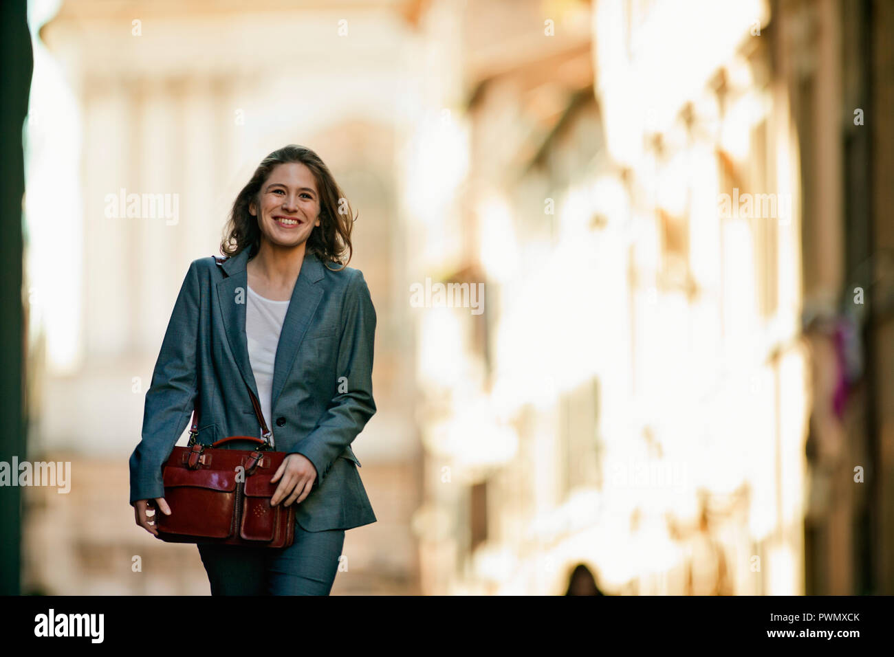 Portrait of a smiling young businesswoman walking home after work. Stock Photo