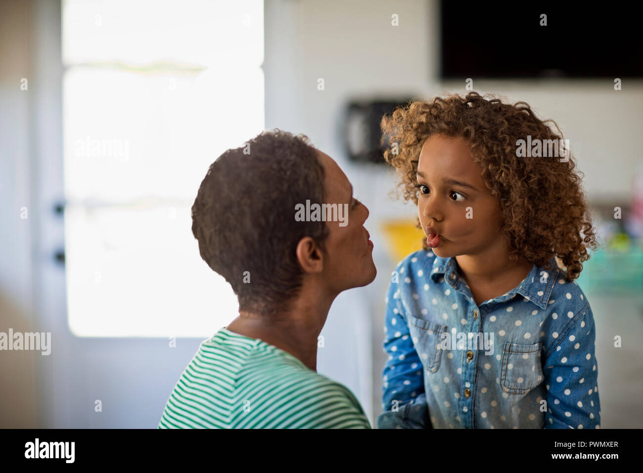 Mother and daughter pulling funny faces at each other. Stock Photo