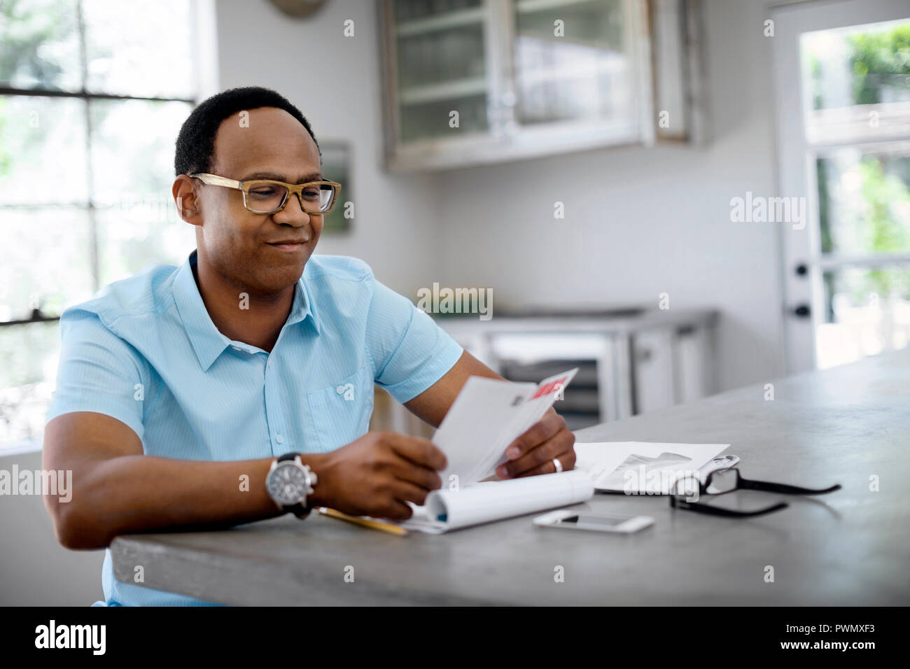 Man reading mail in kitchen. Stock Photo