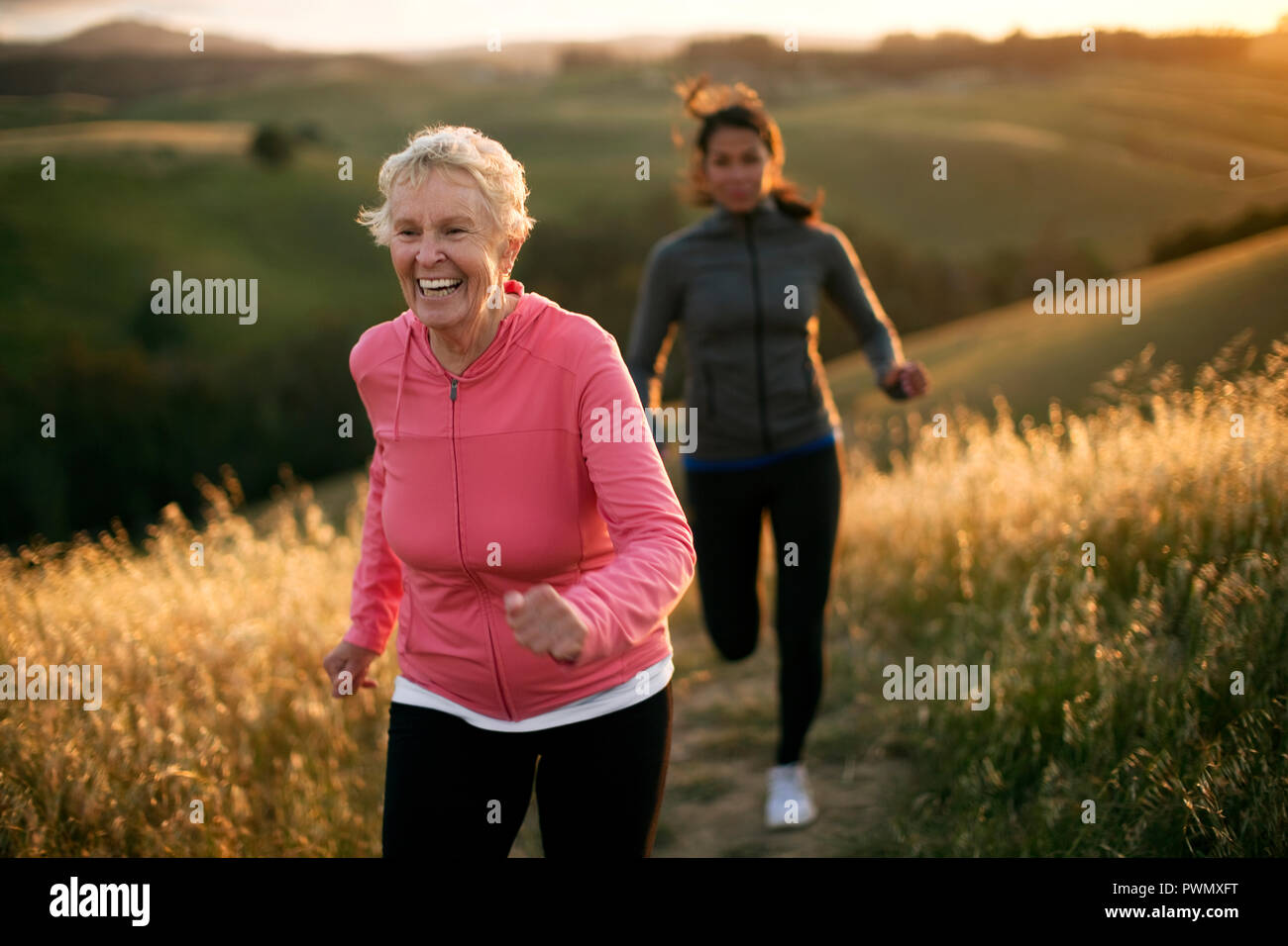 Two women exercising together in a rural landscape. Stock Photo