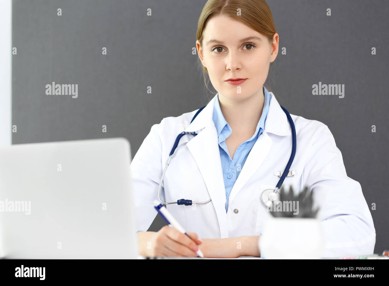 Doctor woman using clipboard with medical record form while sitting