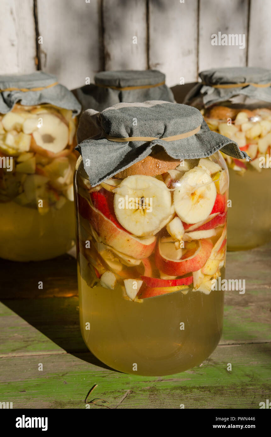 Making of apple vinegar - apple pieces floating on water in a glass Stock Photo