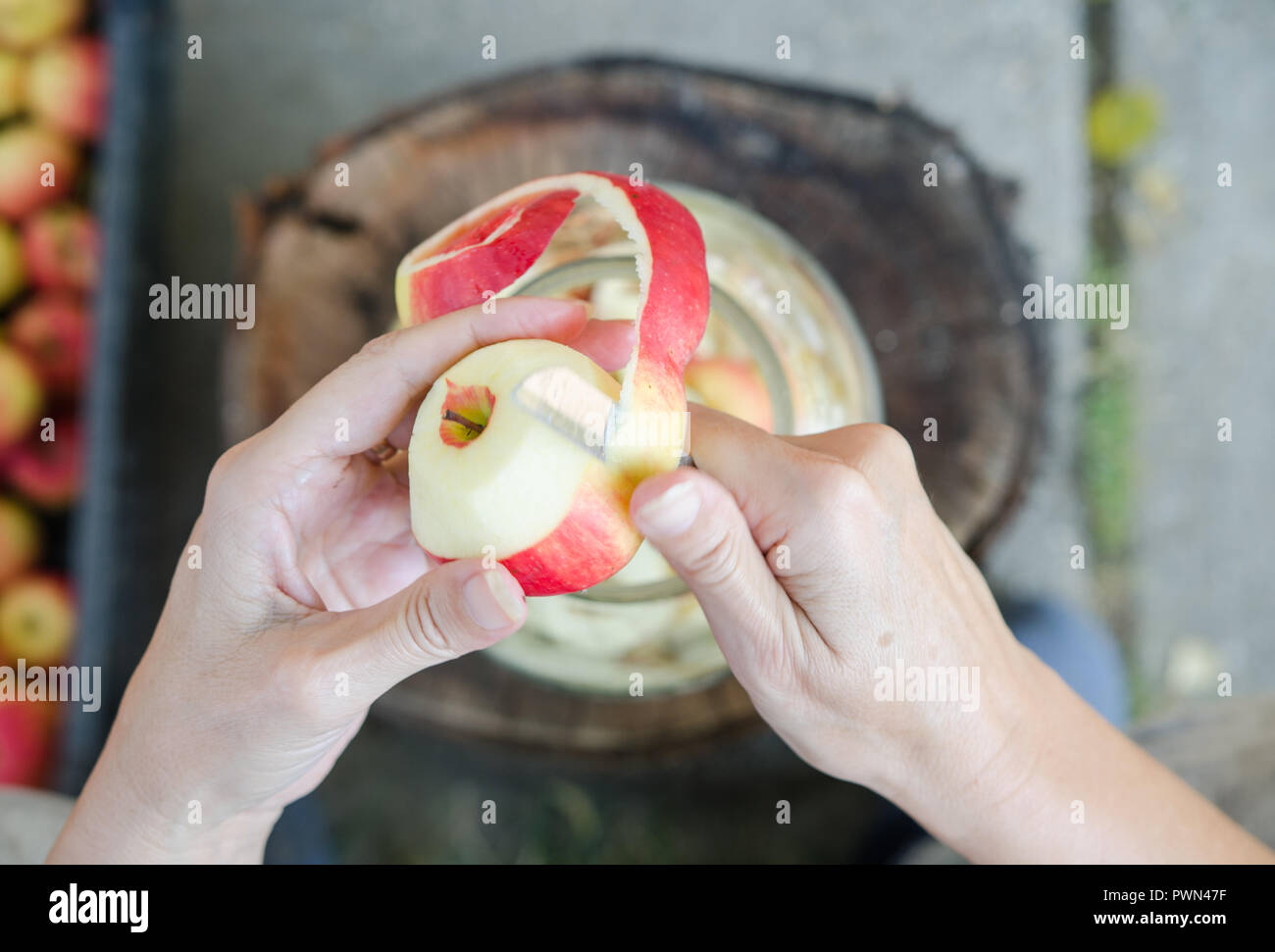 Making of apple vinegar - scene from above - hand peeling apples Stock Photo